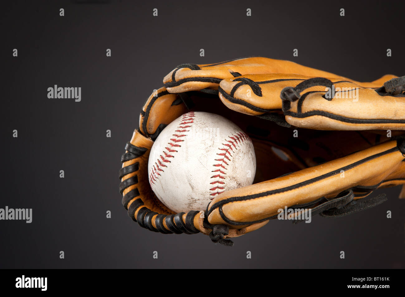 Ein Baseball und Baseball Handschuh Sport-Thema auf einer grauen Steigung, stimmungsvollen Hintergrund. Stockfoto
