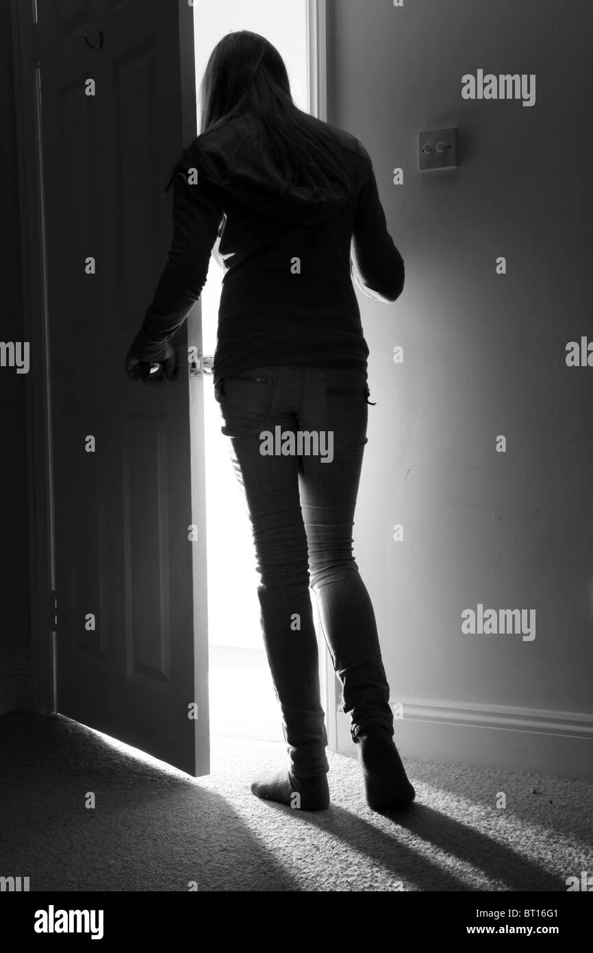 Rückansicht eines jungen Mädchens durch eine offene Tür, voller Länge stehen. Stockfoto