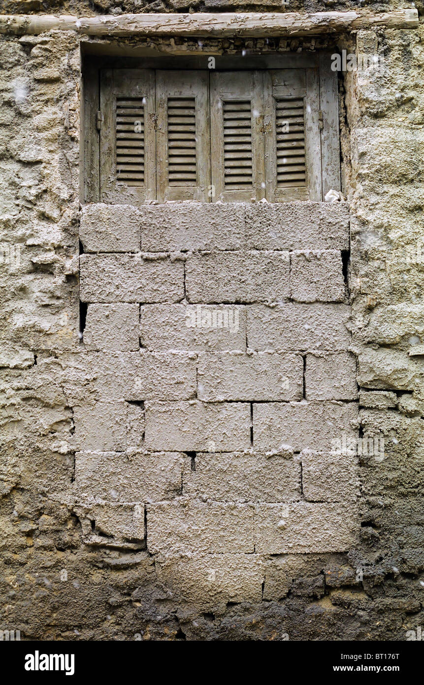 Gemauerte, Fenster und strukturierte Wand eines verlassenen Hauses. Stockfoto
