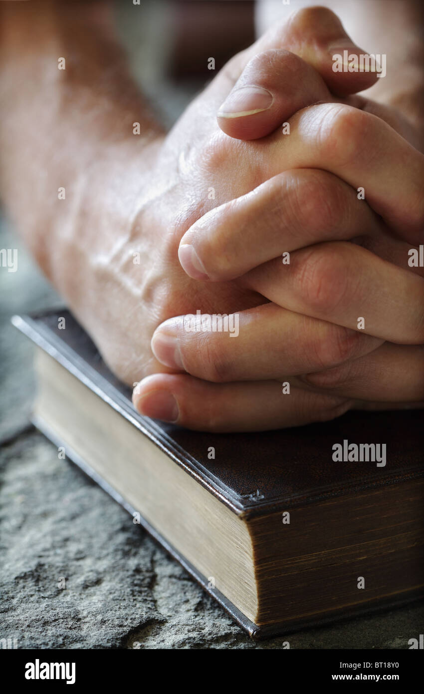 Betende Hände auf eine Bibel Stockfoto