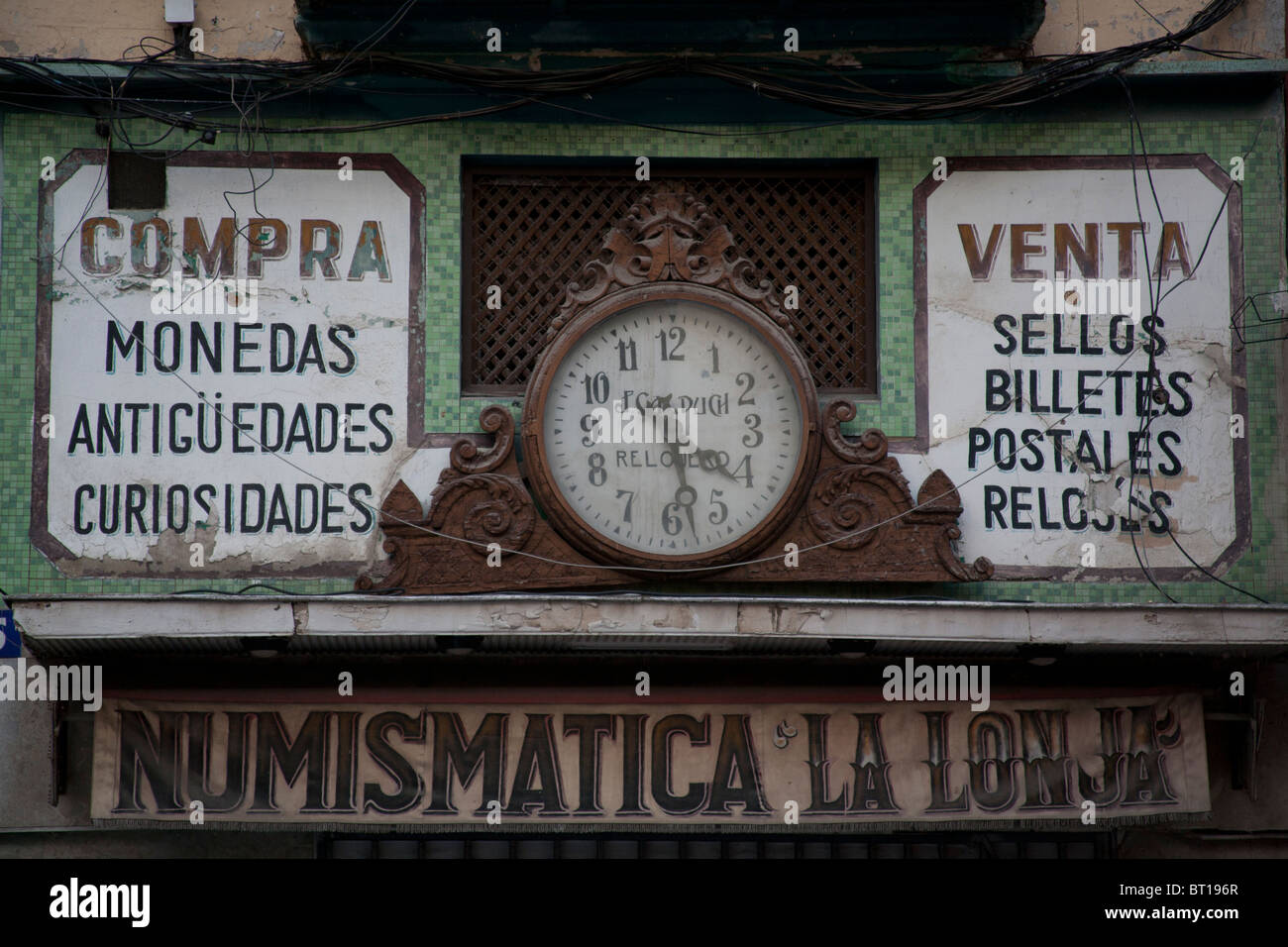 Die Uhr über den Shop-Namen Numismatica La Lonja Valencia, Spanien Stockfoto