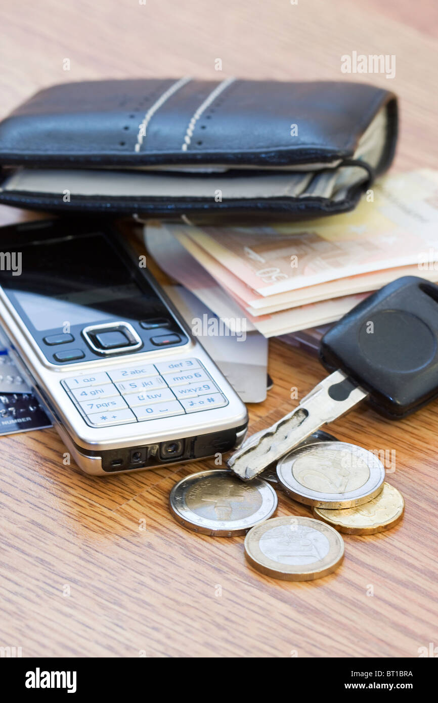 Mans Geldbörse, Handy und Auto Schlüssel auf dem Tisch zu ändern Stockfoto