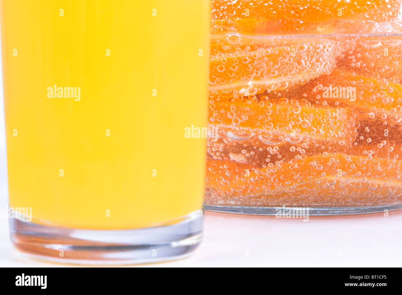Orange in Scheiben im sprudelnden Wasser schneiden. Geringe Schärfentiefe, Fokus auf dem sprudelnden Wasser. Stockfoto