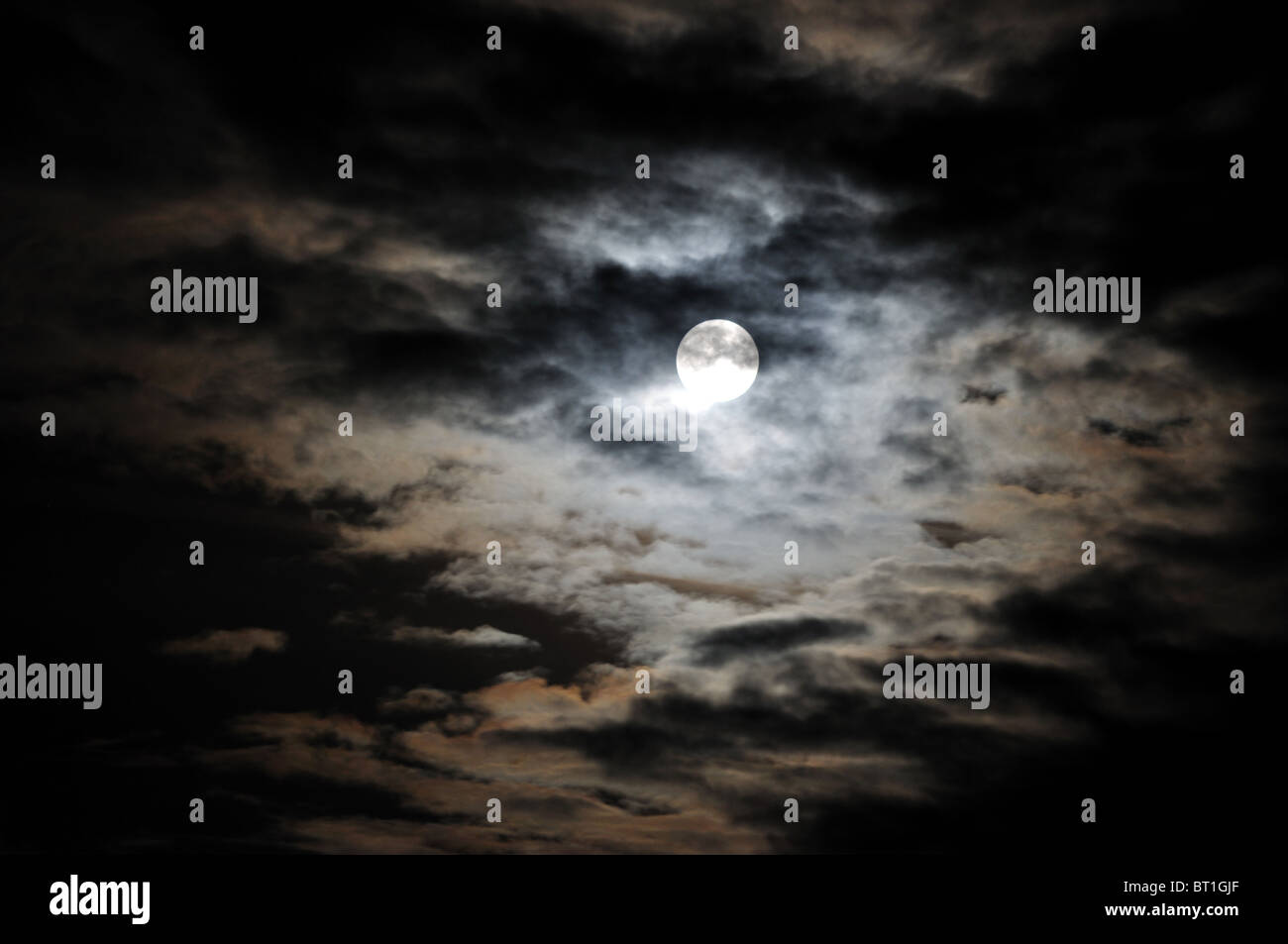 Vollmond und weiße Wolken am schwarzen Nachthimmel Stockfoto