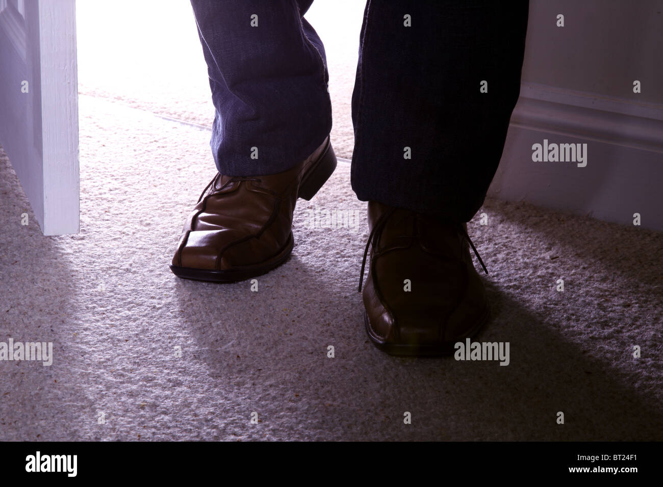 Braune Schuhe des Mannes zu Fuß in ein Zimmer Stockfoto