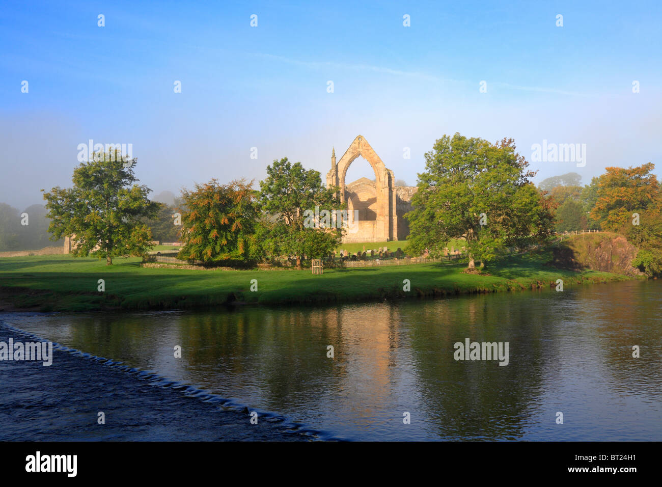 Bolton Priory und Stepping Stones River Wharfe im Herbst Nebel, Bolton Abbey, Yorkshire Dales National Park, North Yorkshire, England, UK. Stockfoto