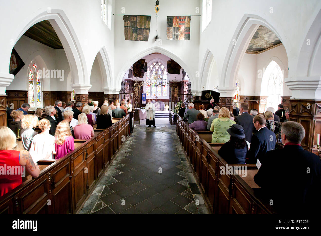 Eine Gemeinde versammeln sich in einem gotischen englische Kirche für eine Trauung stattfinden. Stockfoto