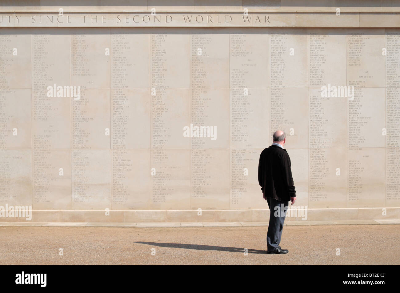 Besucher steht vor einer vollständigen Namen auf der Armed Forces Memorial, National Memorial Arboretum Alrewas, UK. Stockfoto