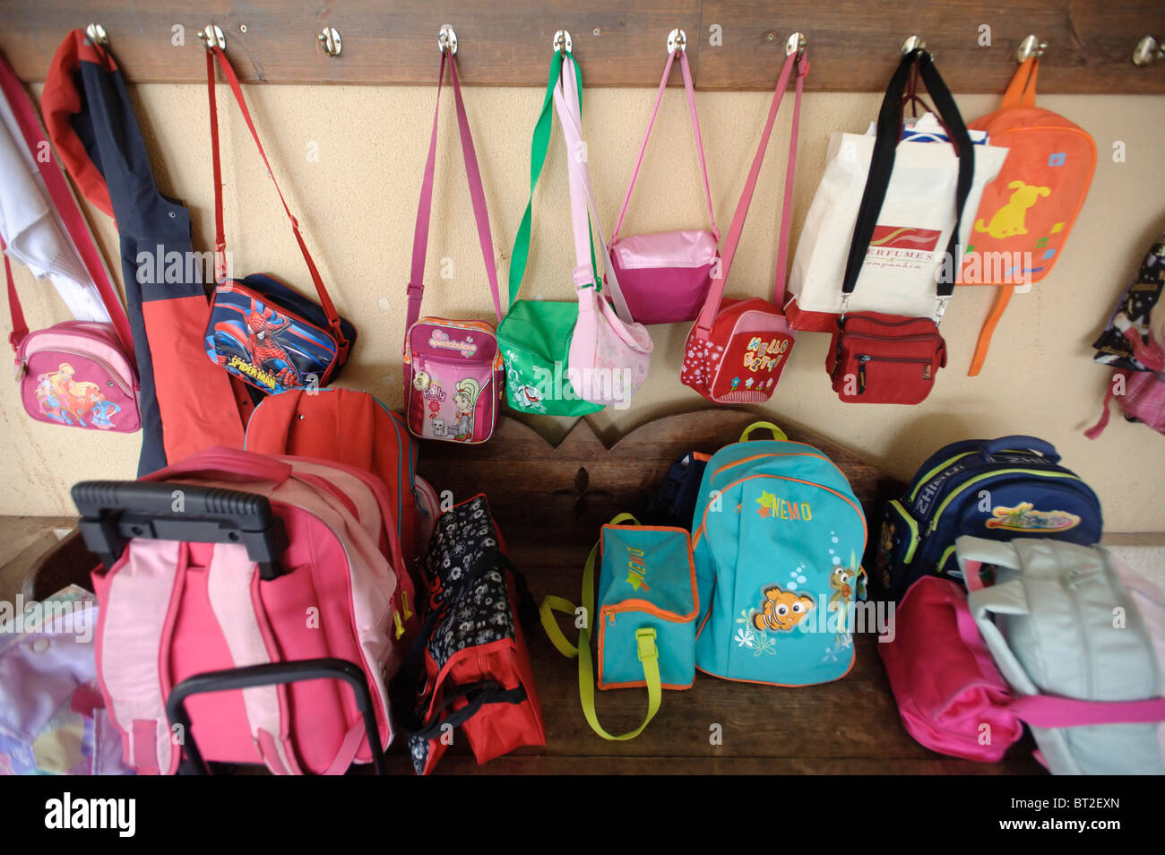 Kinder Taschen und Rucksäcke an Haken hängen und liegen auf dem Boden  außerhalb einer Klasse in einer Grundschule Stockfotografie - Alamy