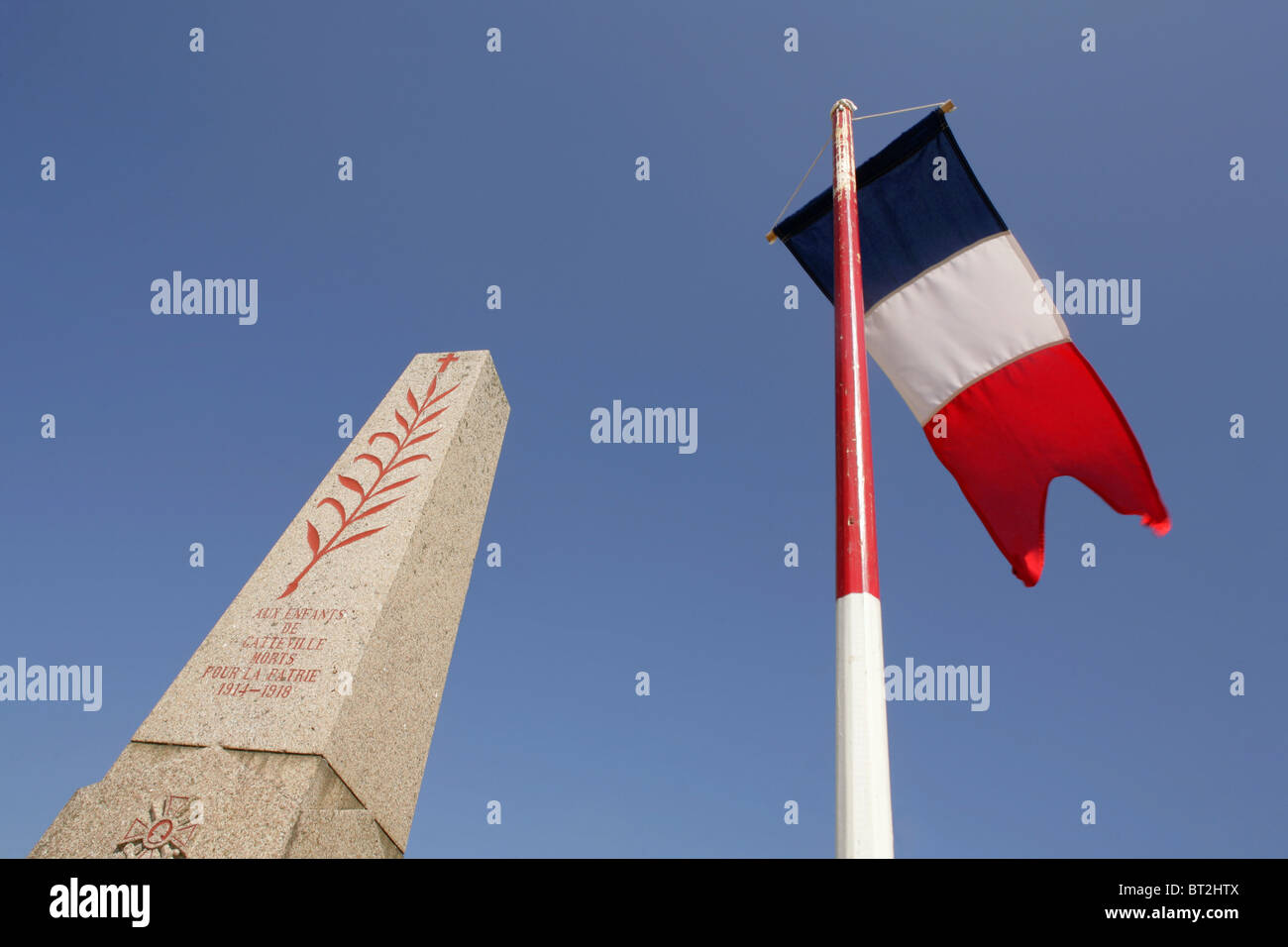 Französische Flagge neben dem ersten und zweiten Weltkrieg Denkmal in Gatteville-le-Phare, Halbinsel Cotentin, Frankreich. Stockfoto