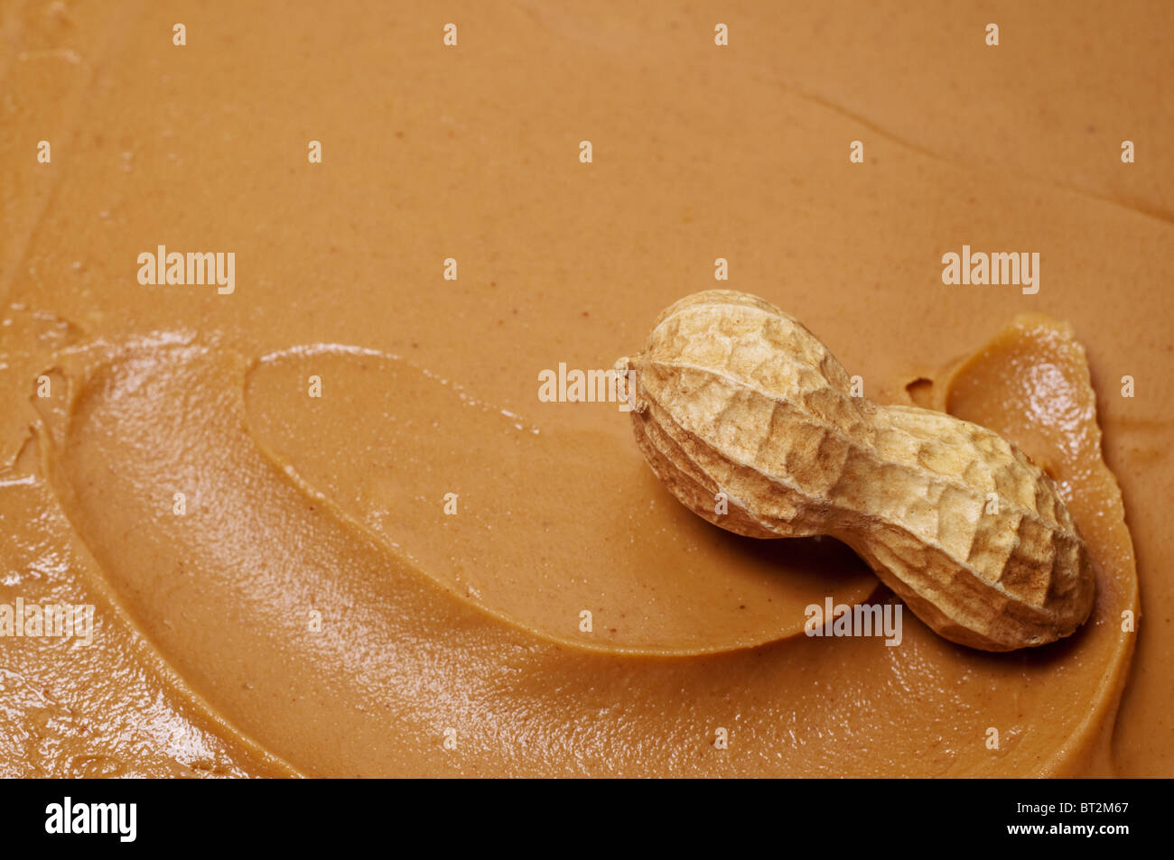 Rohe Erdnüsse im Strudel der cremige Erdnussbutter. Stockfoto