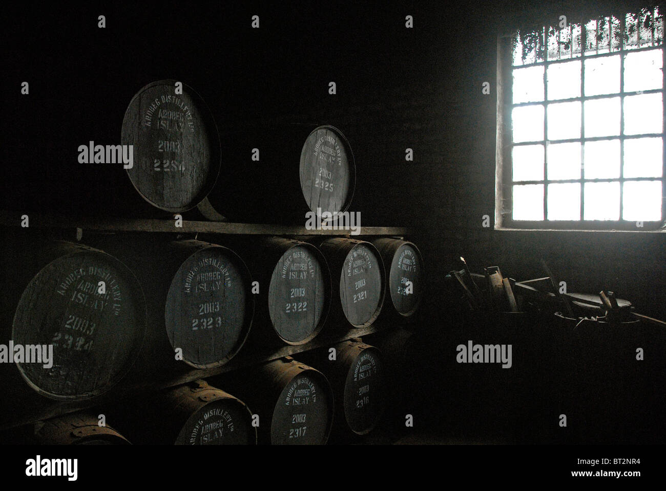 Fässer in einem Lager und Sonne schwebte Fenster auf der rechten Seite. Stockfoto