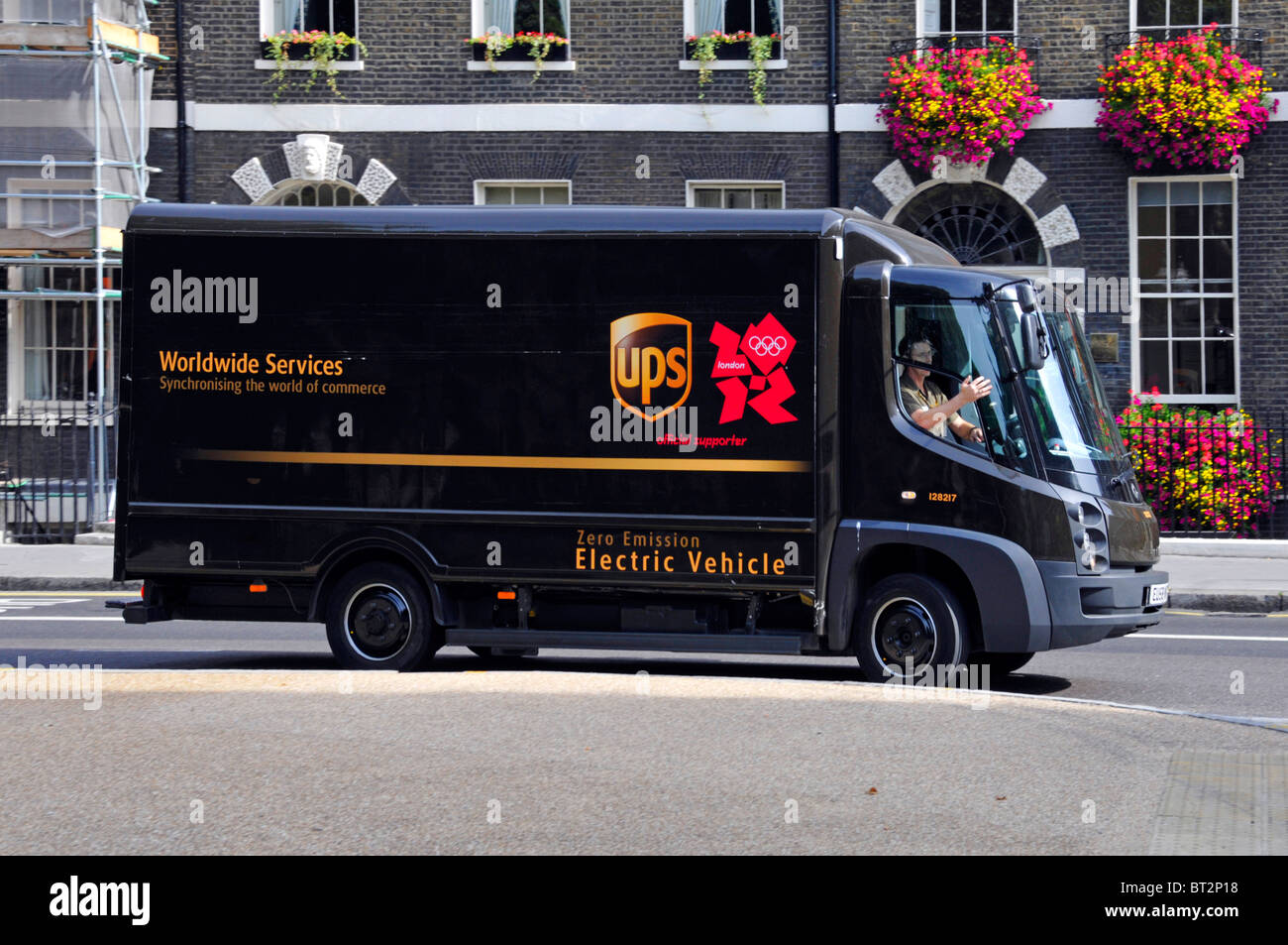 UPS United Parcel Service van, Null Emission elektrischer Lieferwagen & Fahrer in London England UK Olympia Sponsor-logo Stockfoto
