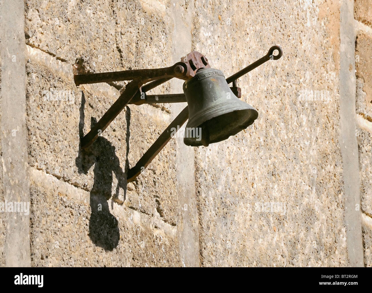 Eine alte Glocke, die an einer Wand hängt Stockfoto