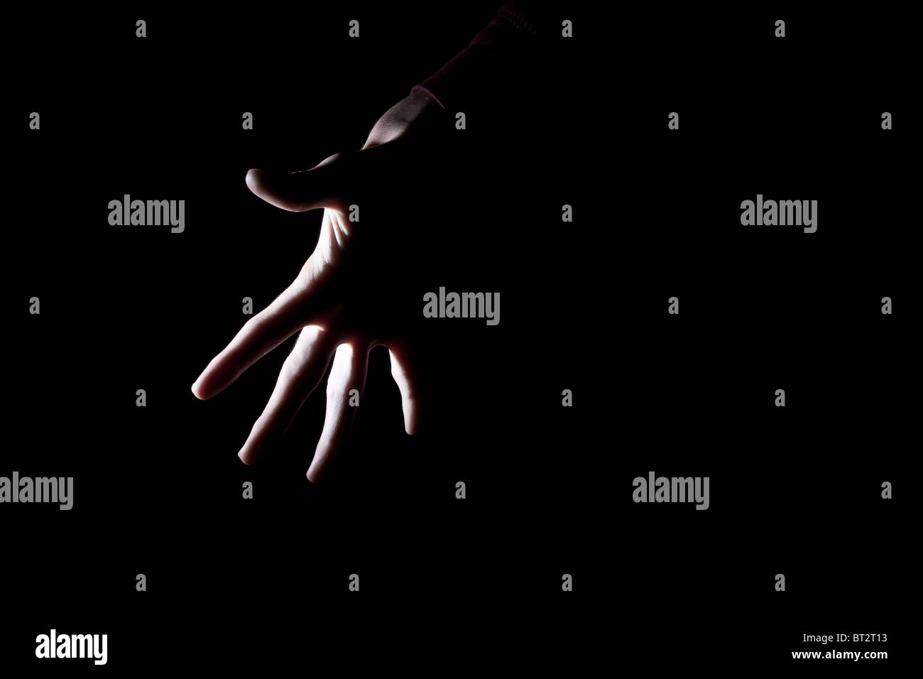 hinterleuchtete Umriss des gruseligen menschliche Hand isoliert auf schwarz für text Stockfoto