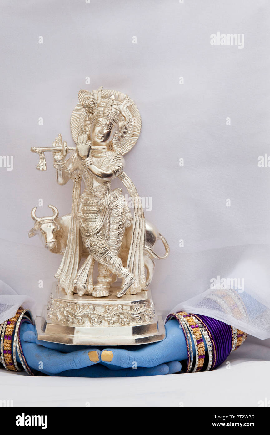 Indische Mädchen hält eine Silber Krishna Statue mit blauen Zeiger Stockfoto