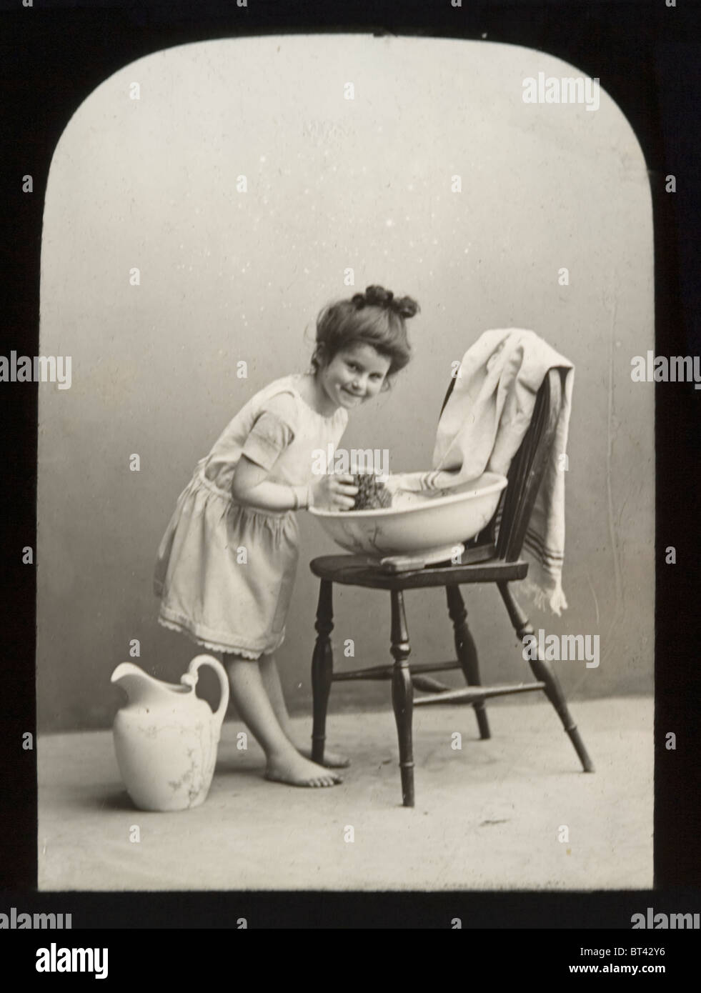 Viktorianischen Laterna-Magica-Folie. Morgen Waschungen. Kind unter ihrem Morgen waschen mit herkömmlichen Krug und Schale. Stockfoto