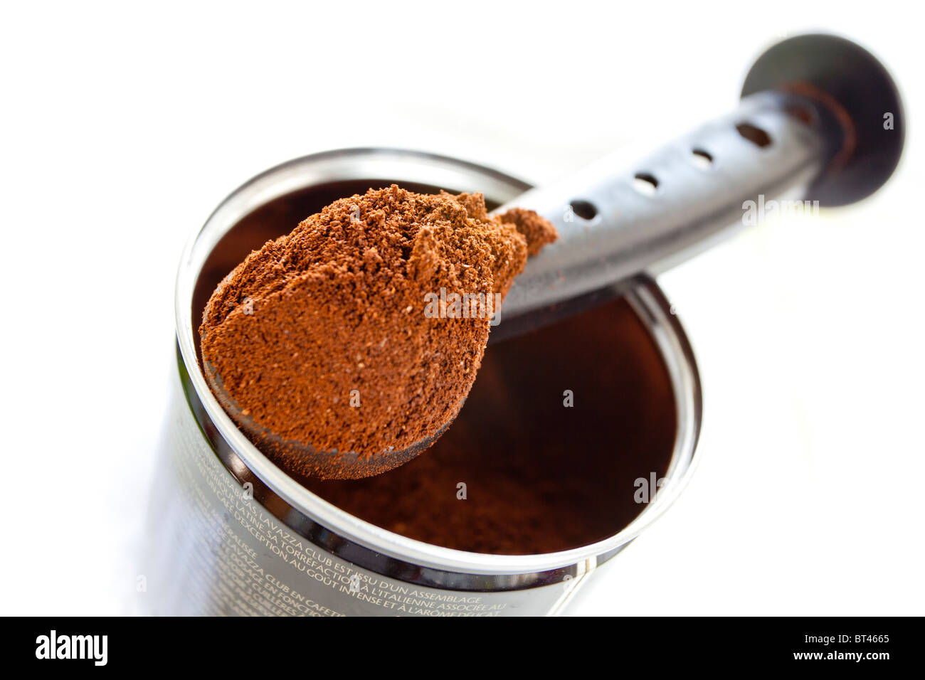 Gemahlener Kaffee in einem Messlöffel über einer Kaffeedose gehäuft Stockfoto