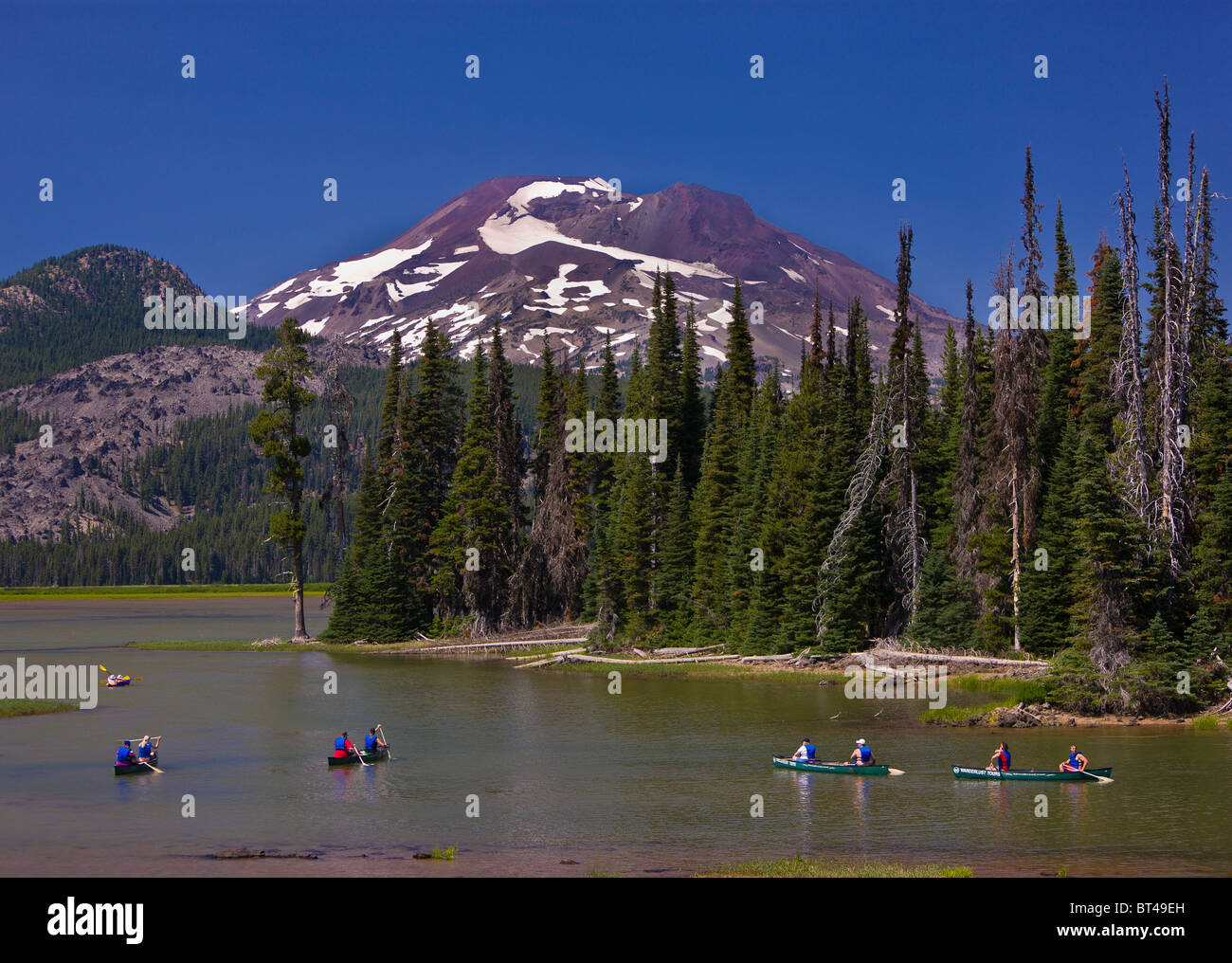 SPARKS LAKE, OREGON, USA - Gruppe von Menschen in Kanus, South Sister, ein Vulkan in den Kaskaden Bergen von Zentral-Oregon. Stockfoto