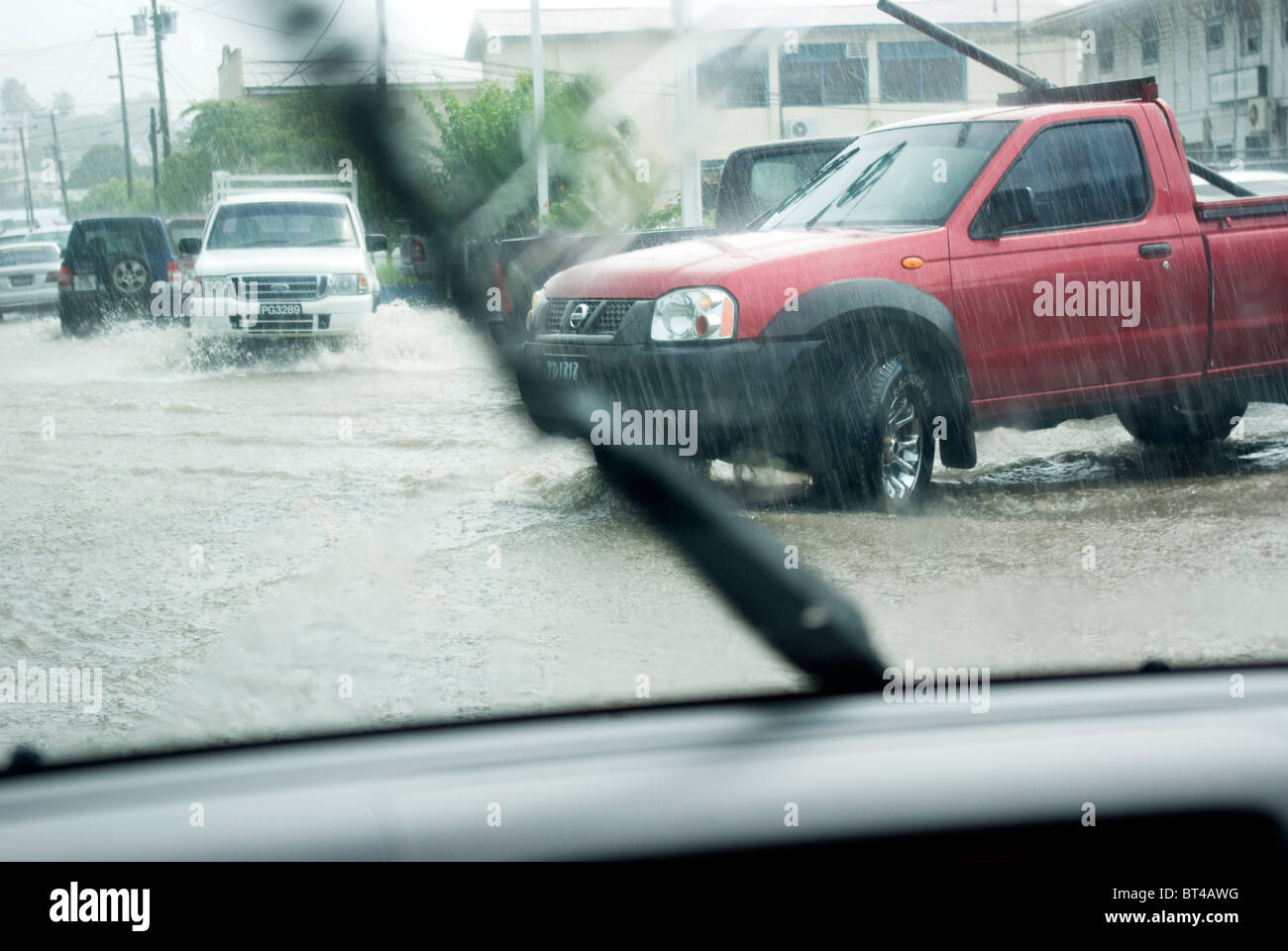 regnerisches Wetter und Hochwasser - Blick vom Fahrzeuginneren. Fahrzeuge fahren in überfluteten Straßen. Stockfoto