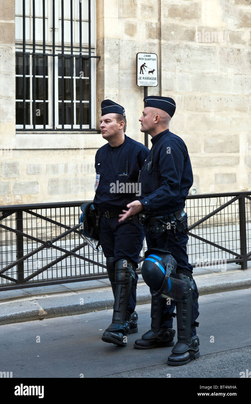 zwei harte aussehende französische Polizisten tragen Schienbeinschoner im Einsatz bei Demonstration durch Schwarzarbeiter Rue de Grenelle Paris Stockfoto
