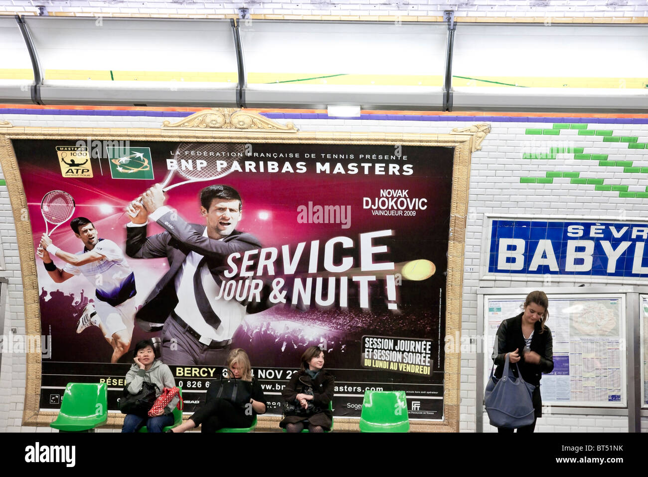 4 unabhängige junge Frauen warten in Sèvres Babylone u-Bahn-Station unter bunte Wand Werbung in verzierten Rahmen trainieren Stockfoto