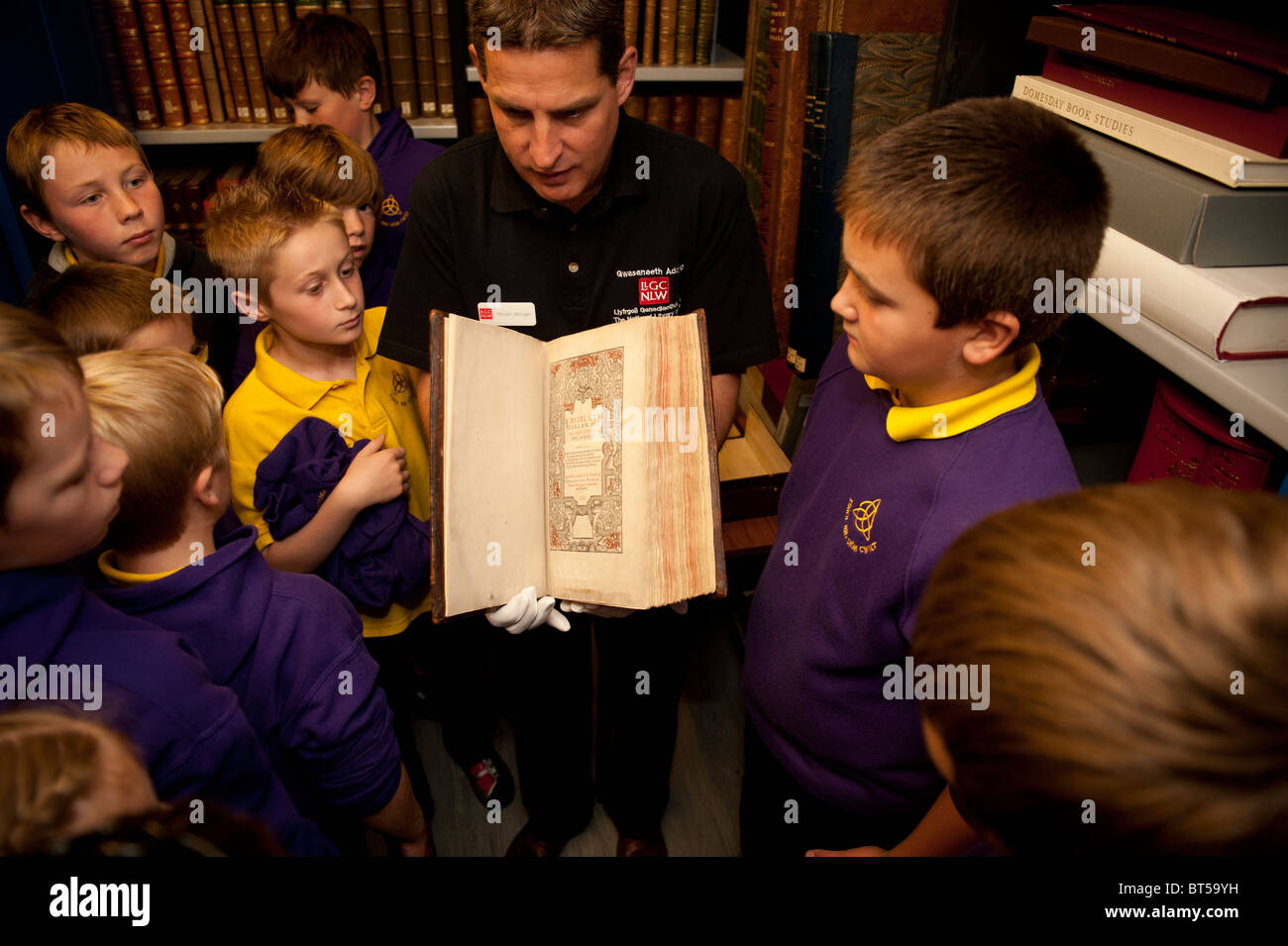 Eine Gruppe Grundschüler besuchen die National Library of Wales, Blick auf die älteste walisische Sprache Bibel Stockfoto