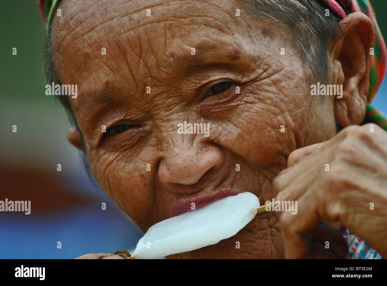 Ältere Frau aus der Flower Hmong-Stamm ein Eis essen, Sapa, Vietnam Stockfoto