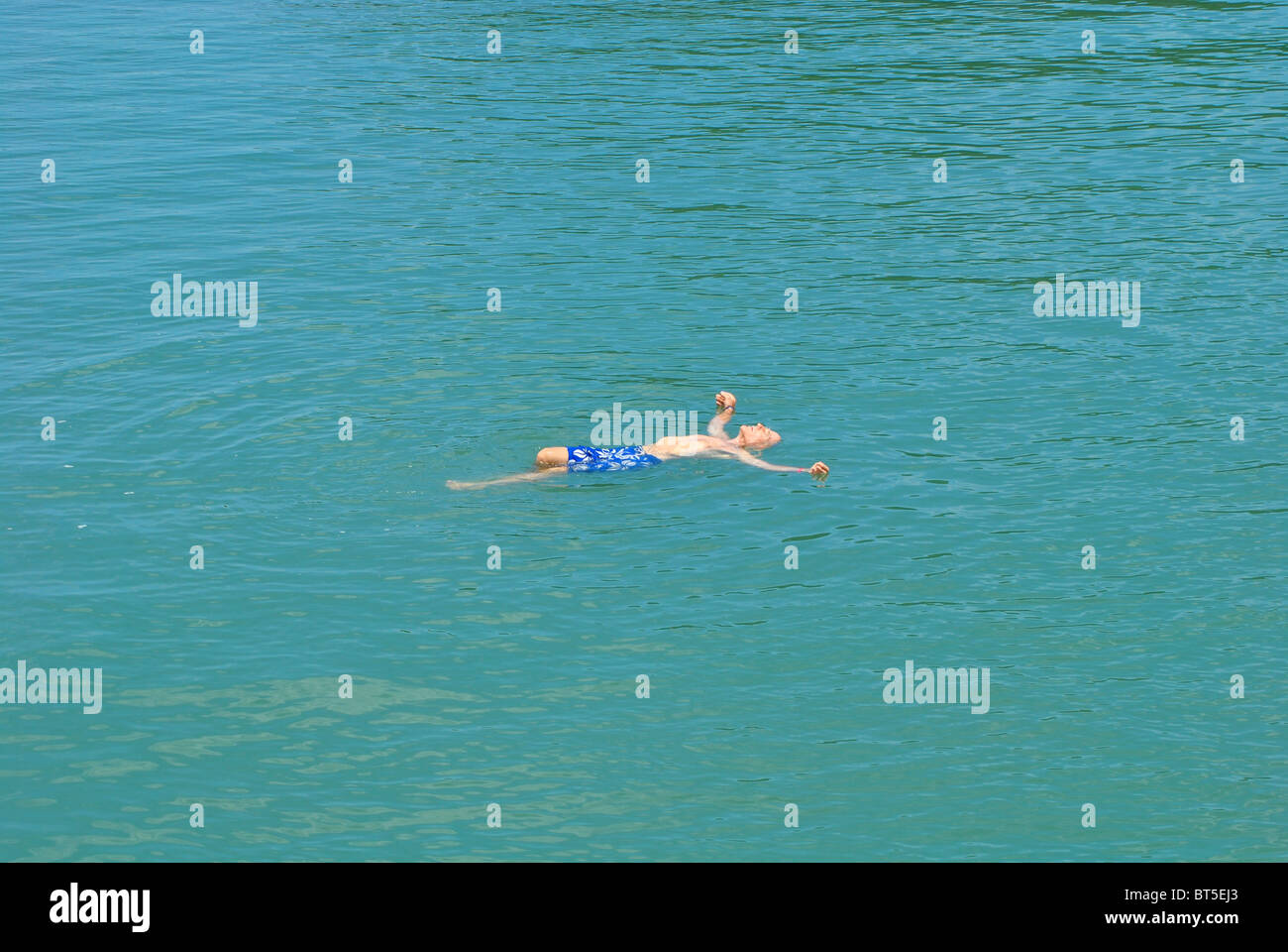 Ältere Touristen schwimmt auf dem Rücken in Halong Bucht, Vietnam Stockfoto