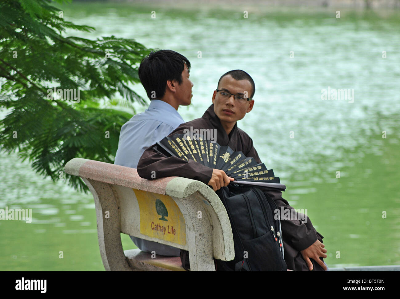 Buddhistischer Mönch mit Ventilator vor Hoan-Kiem-See, Hanoi, Vietnam Stockfoto