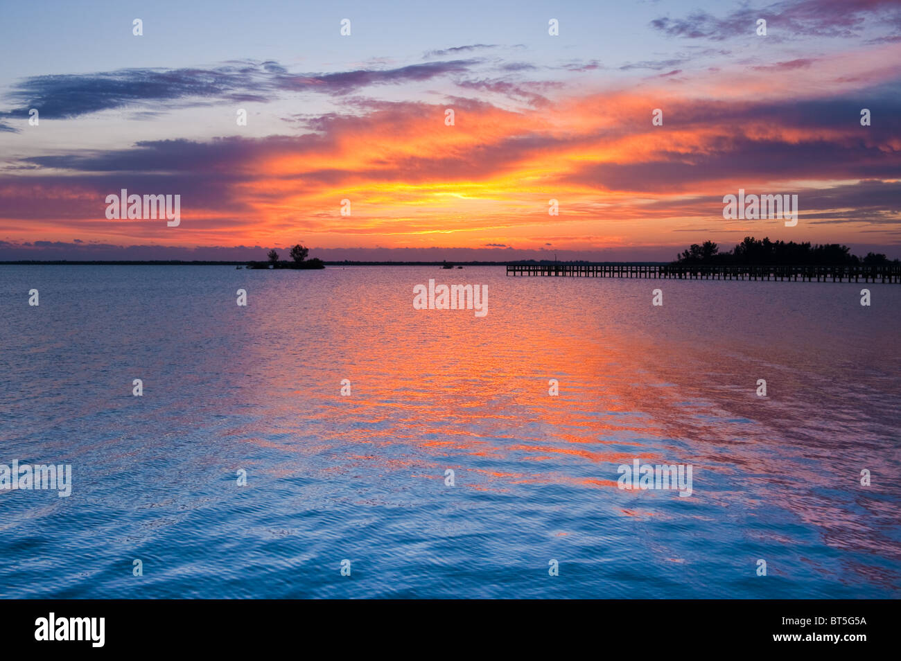 Dramatischer Himmel vor Sonnenaufgang in goldenen Farben auf Indian River, Florida, USA Stockfoto