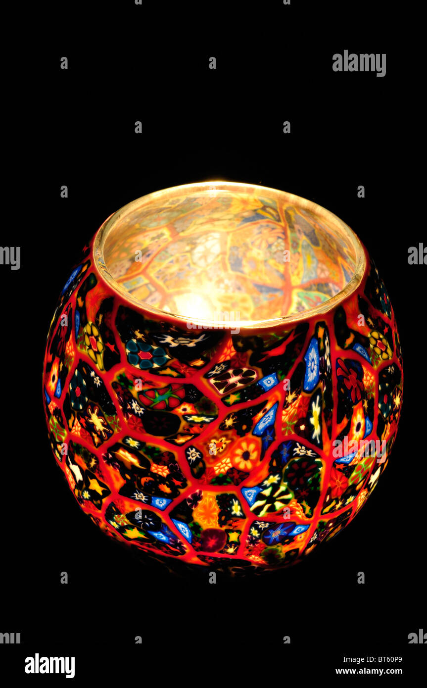 Bunt gemusterte Teelichthalter mit einer brennenden Kerze im Inneren. Oktober 2010 Stockfoto