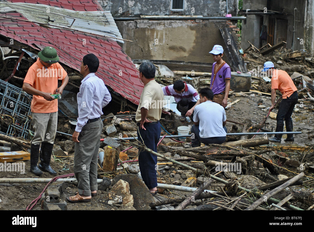 Eingestürzten Haus und Arbeiter nach einem Erdrutsch ausgelöst durch Starkregen in der Nähe von Sapa, Nord-Vietnam Stockfoto