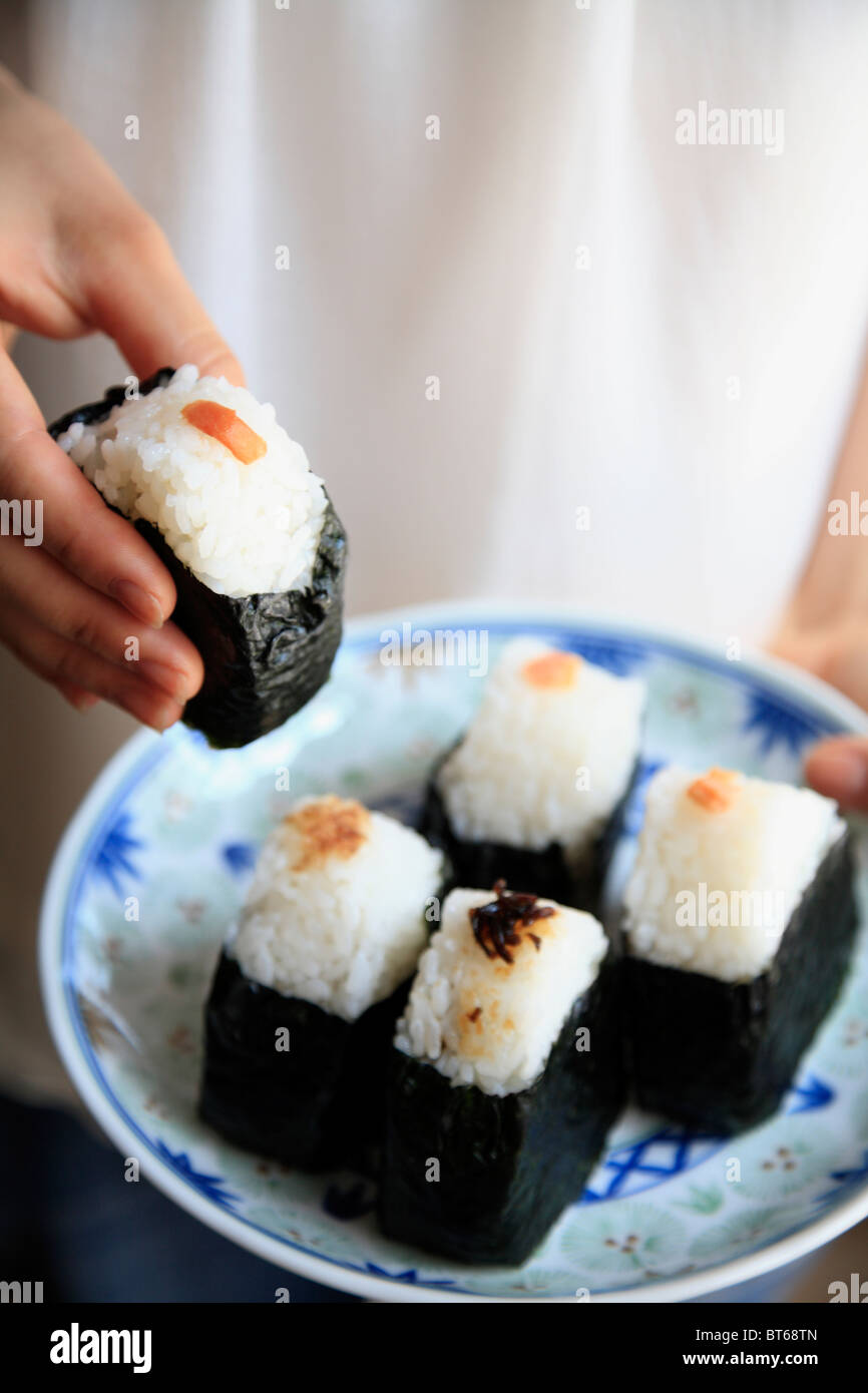 Menschliche Hand hob Reisbällchen Stockfoto