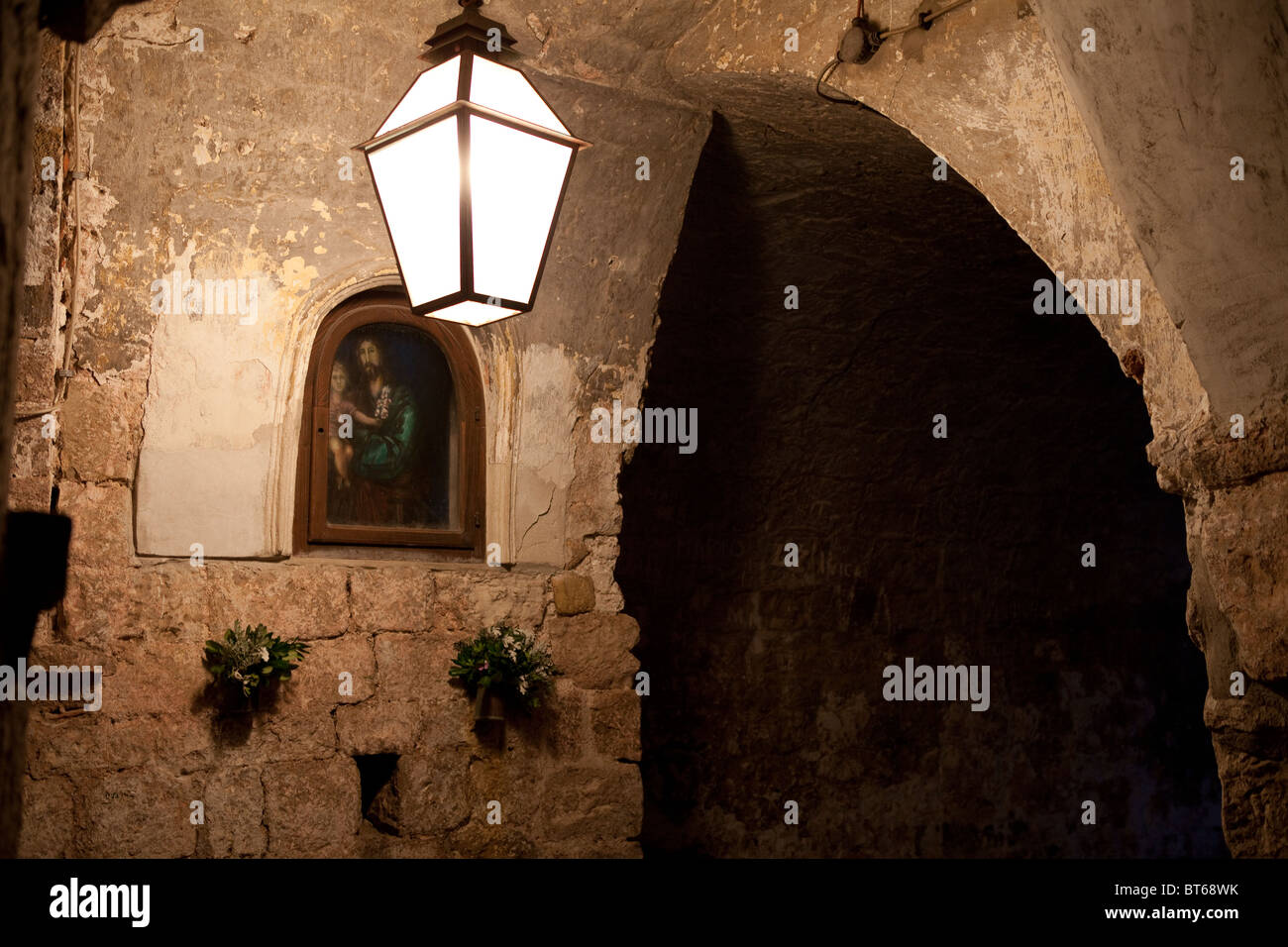 Eines der vielen schönen Gemälde, flankiert von herkömmlichen Leuchten in der Altstadt von Dubrovnik. Stockfoto