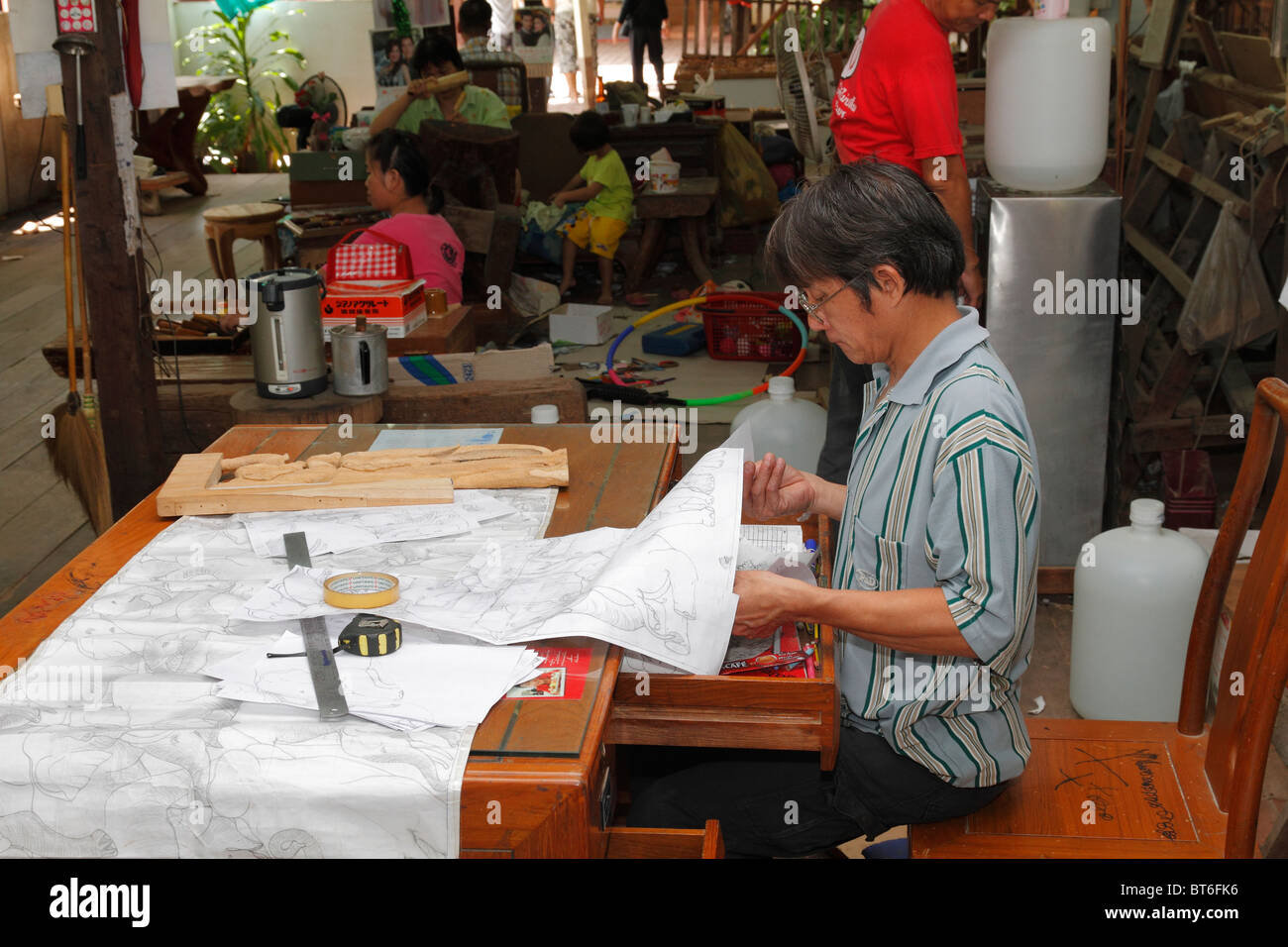 Ein Motiv Mann Designer entwerfen Teak Holz Gravur. Bangkok, Thailand, September 2010 Stockfoto