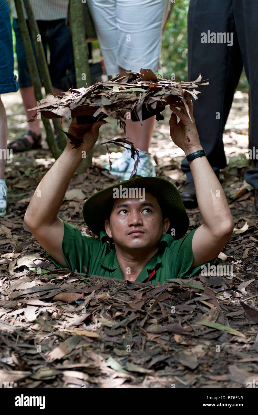 Der Guide zeigt Tunnel ein und Tarnung Techniken für Touristen. Cu Chi