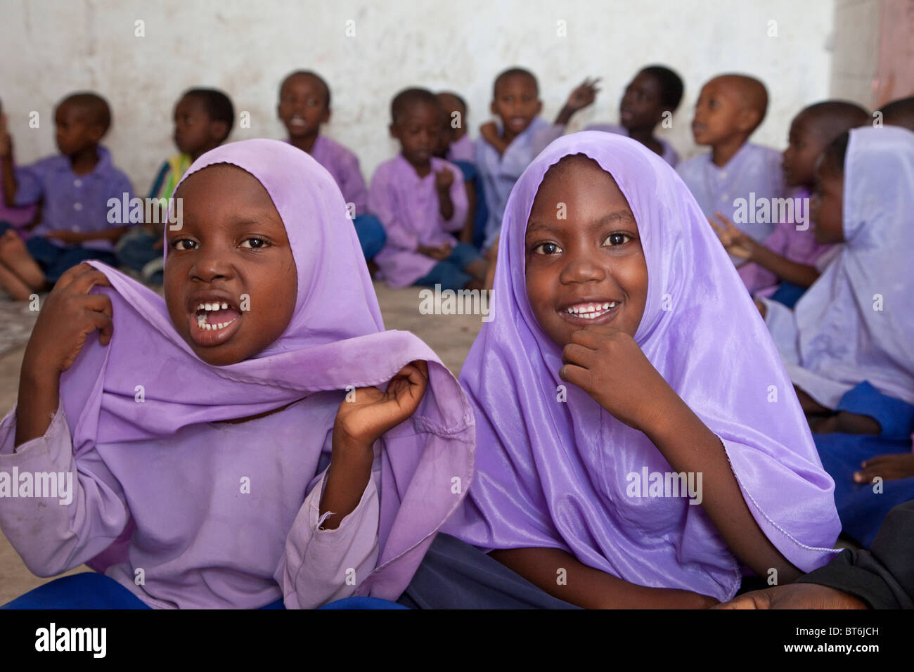 Jambiani, Sansibar, Tansania. Muslimische Schülerinnen. Die Schüler sitzen auf dem Boden und die Schule hat keine Möbel. Stockfoto