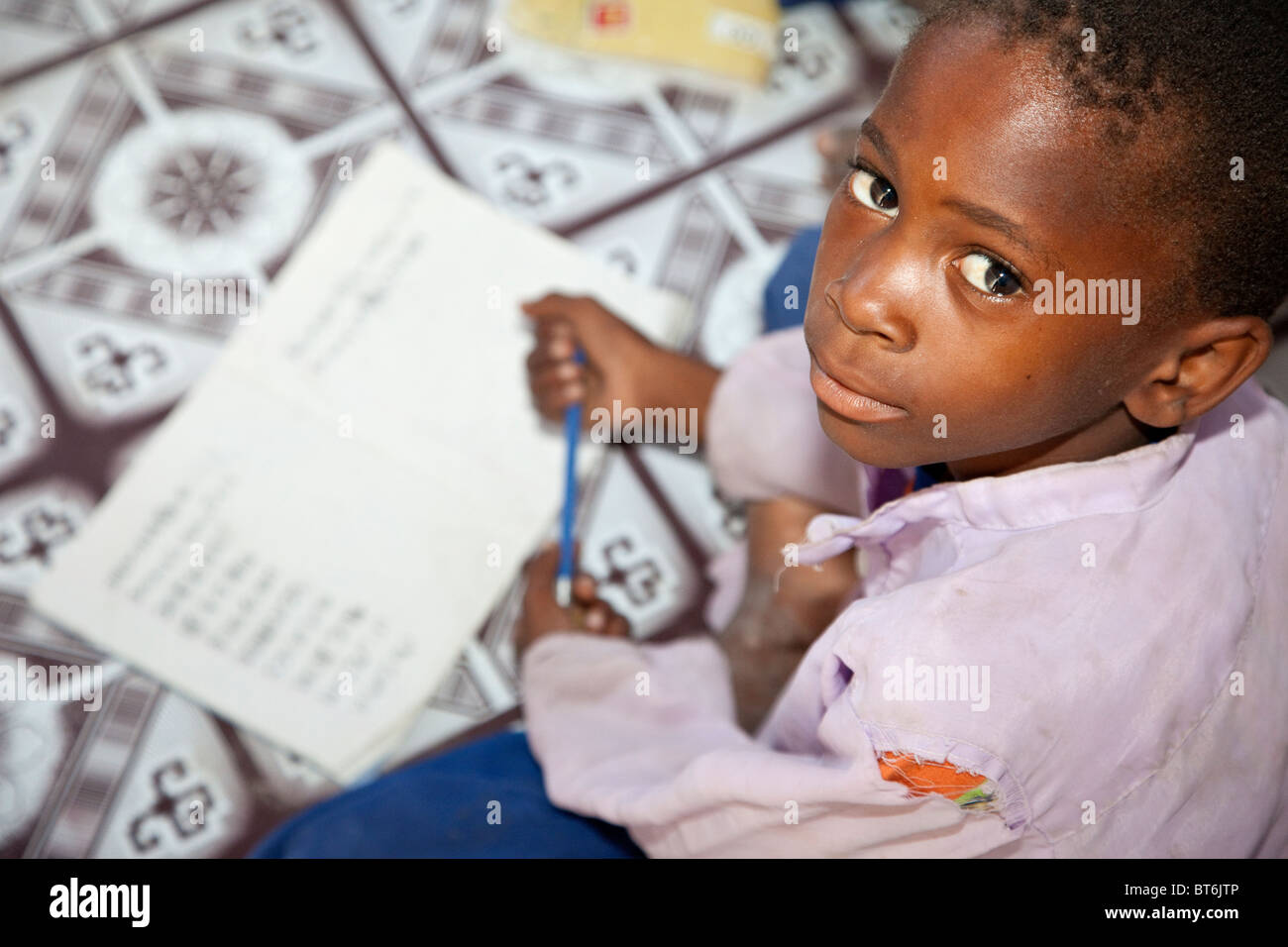 Jambiani, Sansibar, Tansania. Muslimischen afrikanischen Schuljunge mit seinem Copybook. Stockfoto