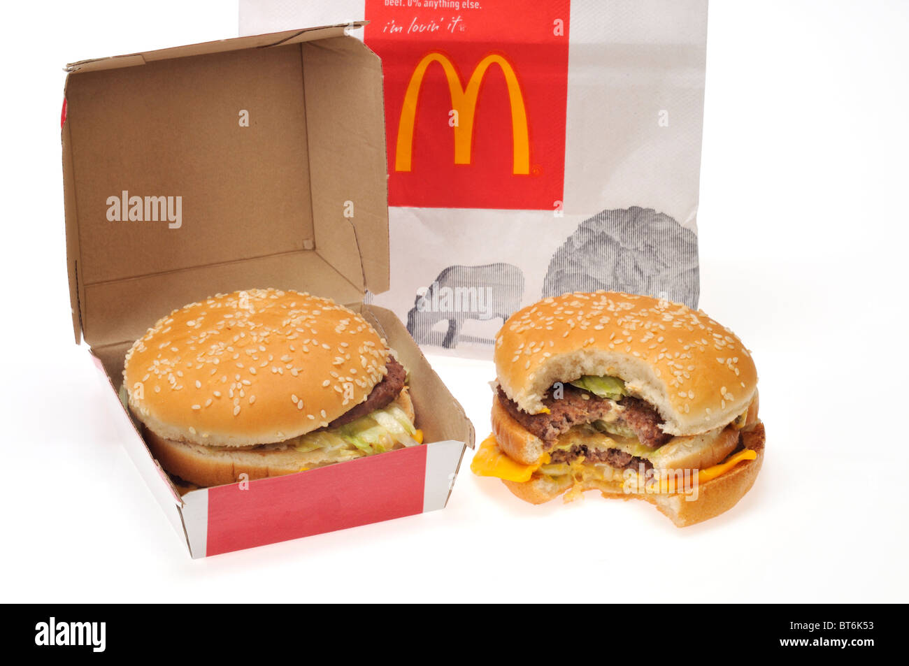 McDonald's Tasche mit 2 Big Mac Sandwiches und Karton und hat einen Bissen von es auf weißem Hintergrund ausschneiden Stockfoto