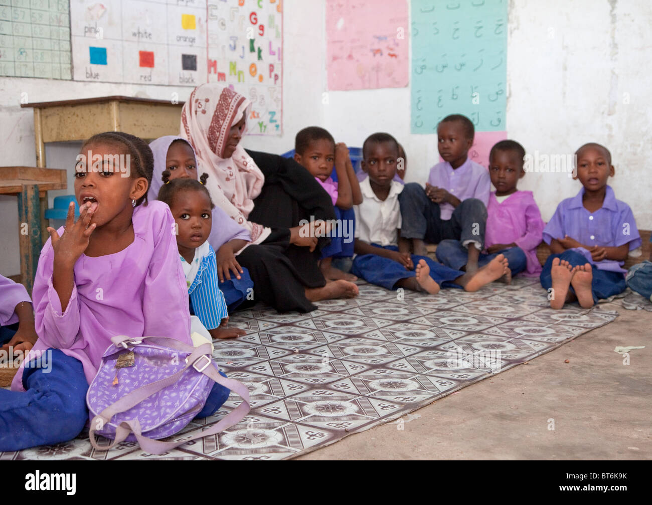 Jambiani, Sansibar, Tansania. Grundschule Unterricht und Kinder. Die Schüler sitzen auf dem Boden und die Schule hat keine Möbel. Stockfoto