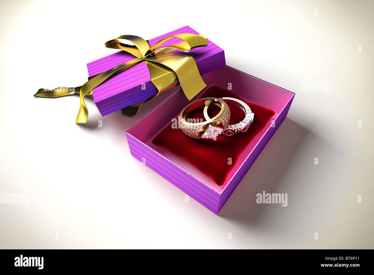 Zwei Ringe mit Diamanten und Steinen, in einer offenen Geschenkbox mit roten Kissen Stockfoto