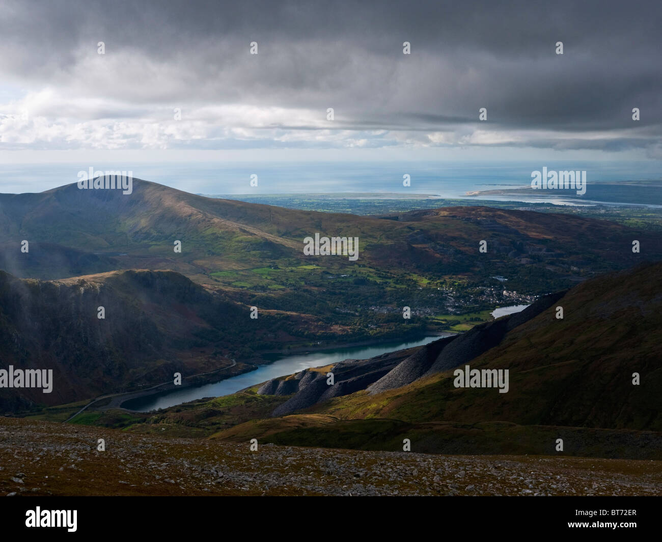 Llanberis, eingebettet zwischen Moel Eilio und Llyn Peris in Snowdonia. Beute Haufen aus Dinorwig Schiefer-Steinbrüche sind sichtbar. Stockfoto