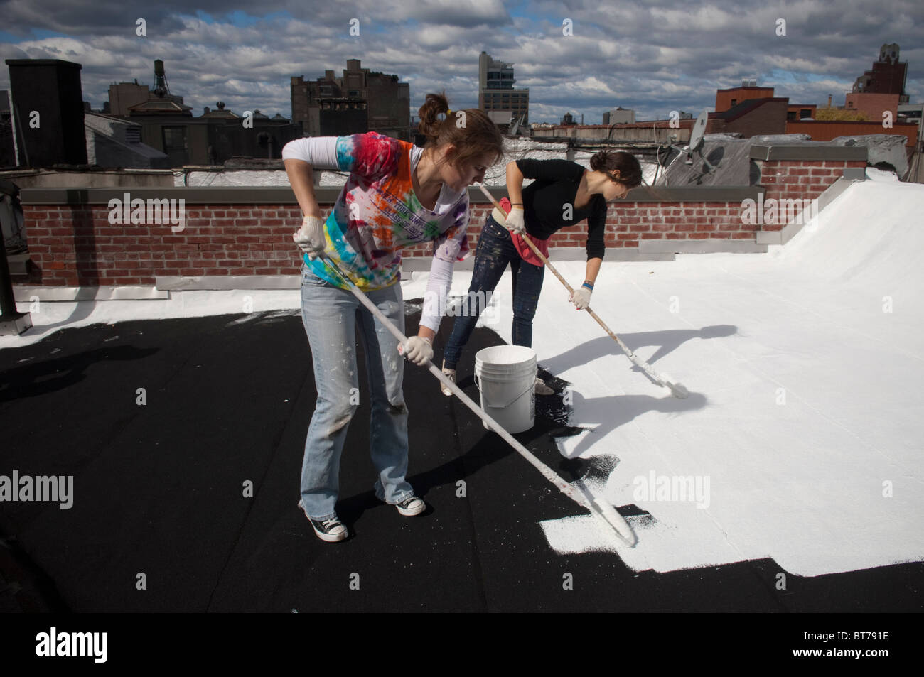 College Student Volunteers malen ein Coolroof nahe dem Times Square in New York weiß Stockfoto