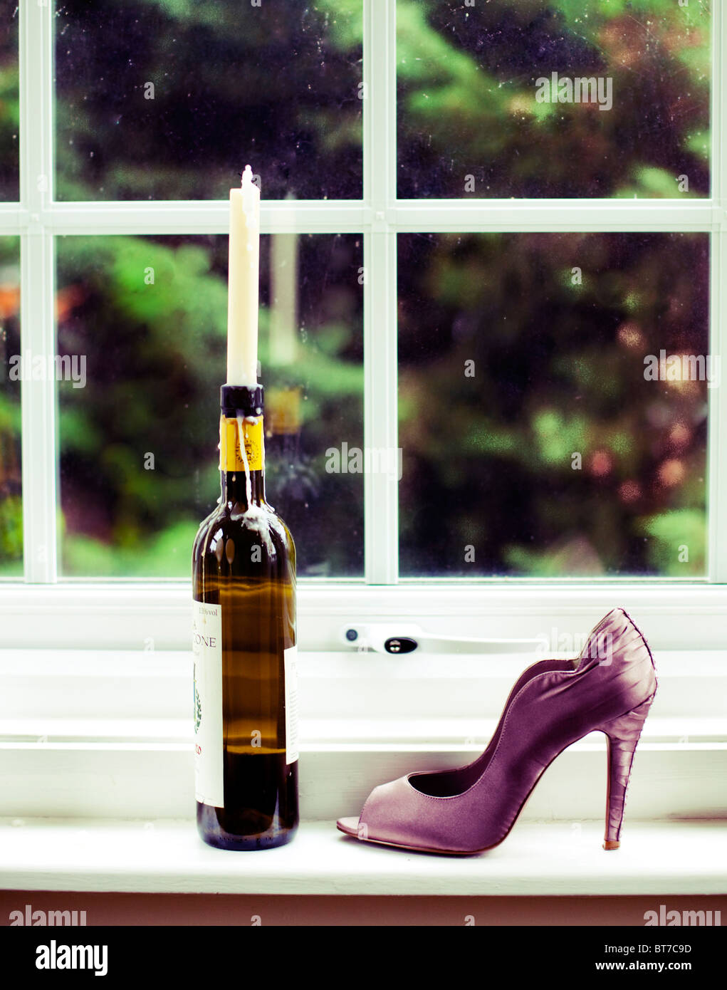 Damen Schuh und Flasche mit Kerze auf Fensterbank, UK Stockfoto