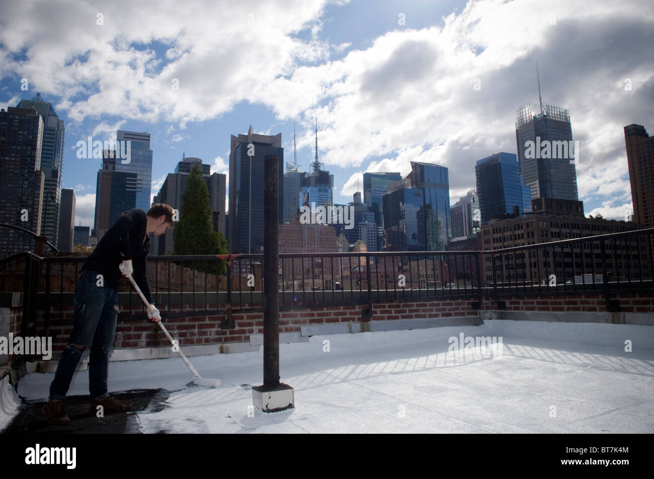 College Student Volunteers malen ein Coolroof nahe dem Times Square in New York weiß Stockfoto