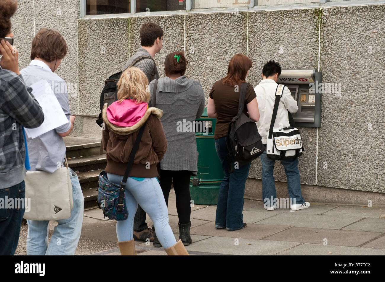 Aberystwyth Universitätsstudenten Schlange, um ein Geldautomat HSBC, UK verwenden Stockfoto