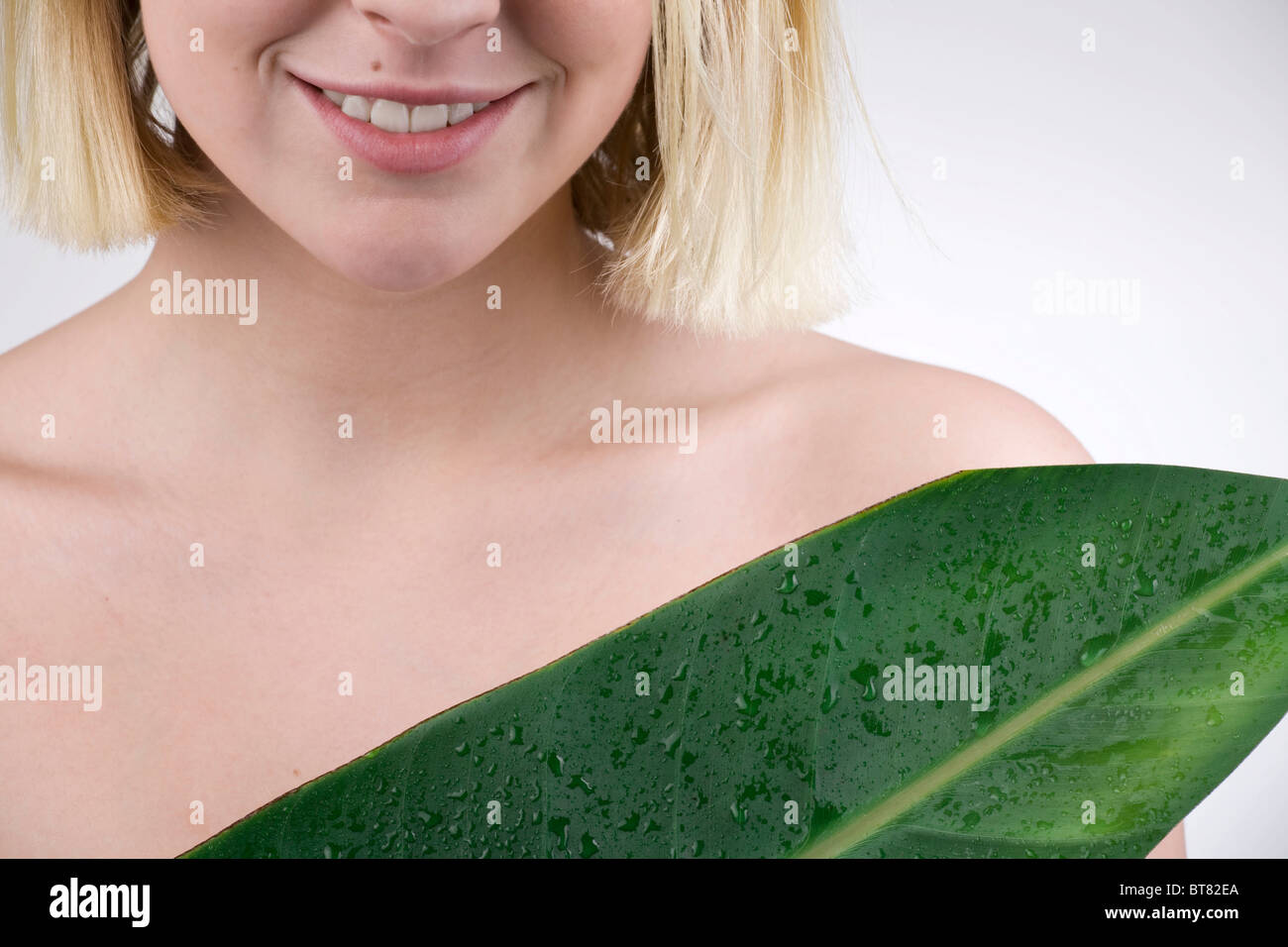 Junge Frau mit einem Blatt, Feuchtigkeit und empfindliche Haut Stockfoto