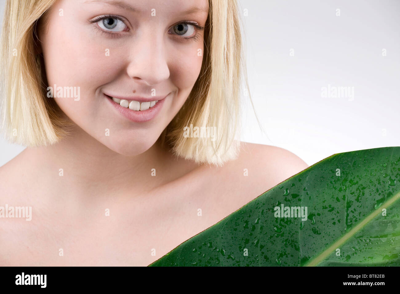 Junge Frau mit einem Blatt, Feuchtigkeit und empfindliche Haut Stockfoto