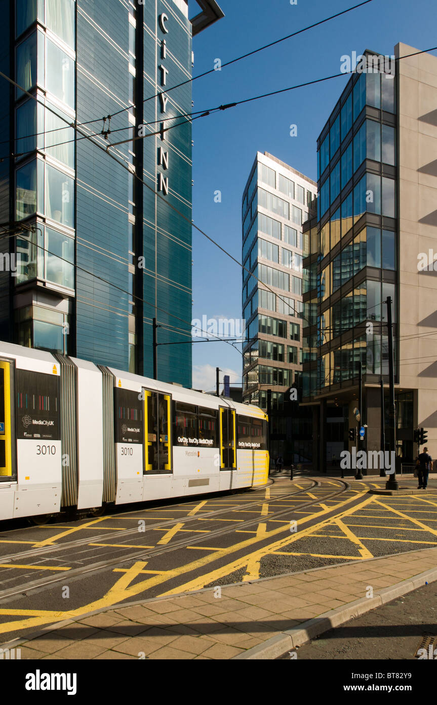 Metrolink Straßenbahn nähert sich der Piccadilly Place Entwicklung, Manchester, England, UK.  City Inn Hotel auf der linken Seite. Stockfoto